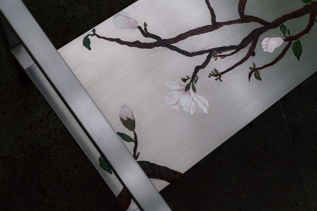 Detalle de las ramas de magnolia sobre el acero cepillado
