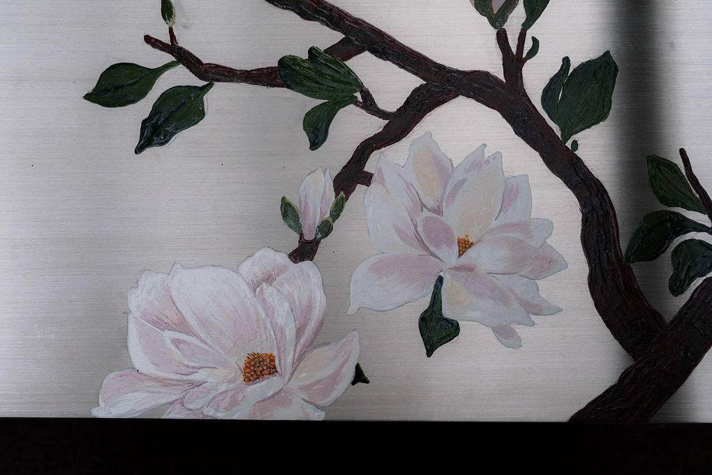 Detalle de las ramas de magnolia sobre el acero cepillado